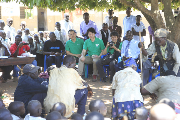 Participating in a meeting in Uganda.